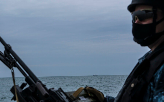 Một lính Nga tuần tra trên biển Azov ngày 19/4, cách đó không xa là một tàu của Nga. (ảnh: NYT)