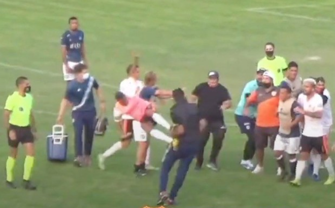 HLV đội khách Perdiechizi khơi nguồn cho màn loạn đả nhưng chính ông cũng bị ngã văng cả mét sau cú song phi bằng 2 chân của cầu thủ đối phương (Ảnh: Chụp màn hình)