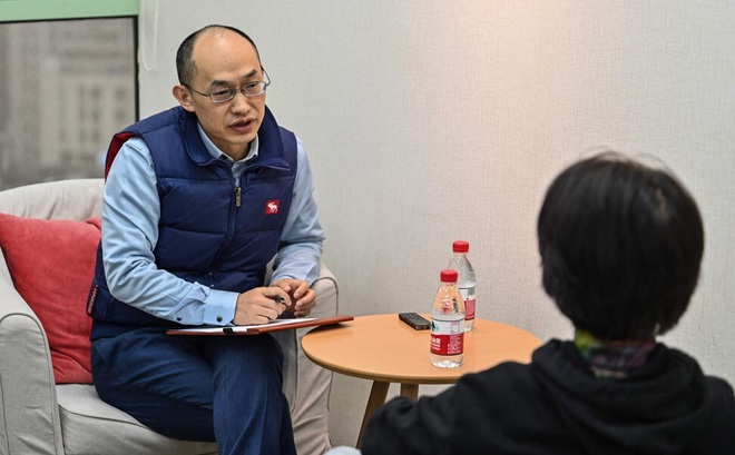 Cố vấn Zhu Shenyong (bên trái) tư vấn cho một kháng hàng. Ảnh: AFP