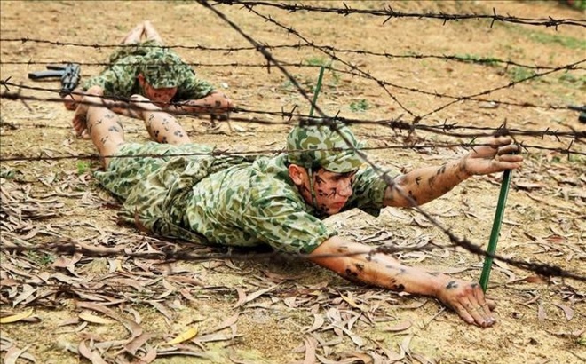 Chiến sĩ đặc công Việt Nam thực hành khắc phục vật cản, trườn qua dây thép gai. Ảnh: Thông tấn xã Việt Nam.