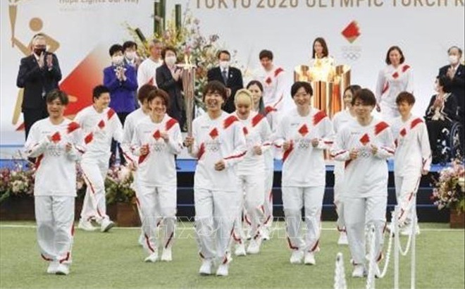 Các thành viên trong đội tuyển từng vô địch giải World Cup bóng đá nữ năm 2011 là những vận động viên chạy tiếp sức đầu tiên trong cuộc rước đuốc Olympic Tokyo, tại trung tâm đào tạo bóng đá quốc gia J-Village, tỉnh Fukushima, Nhật Bản, ngày 25/3/2021. Ảnh: Kyodo/TTXVN