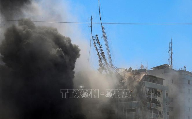 Tòa tháp Jala, nơi đặt văn phòng một số hãng truyền thông quốc tế, bị đổ sập do trúng không kích của Israel tại Dải Gaza, ngày 15/5/2021. Ảnh: AFP/TTXVN