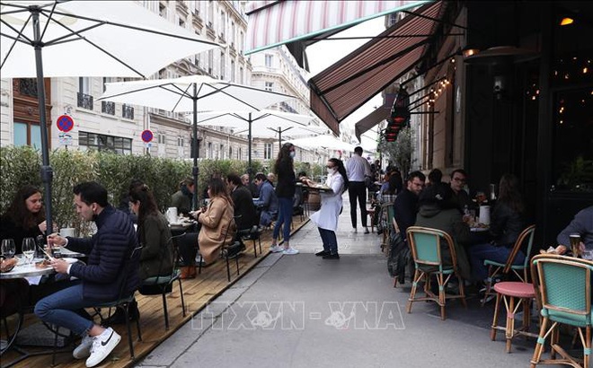 Người dân dùng bữa tại một nhà hàng ngoài trời ở Paris, Pháp, ngày 19/5/2021. Ảnh: THX/TTXVN
