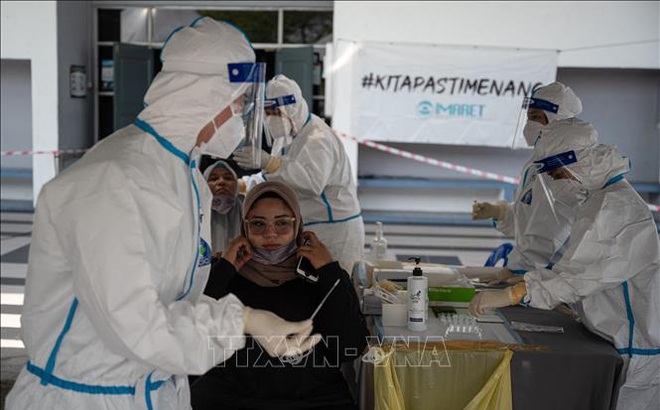 Nhân viên y tế lấy mẫu xét nghiệm COVID-19 tại Kuala Lumpur, Malaysia. Ảnh: AFP/TTXVN