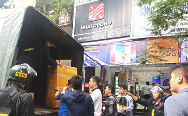 Lực lượng cảnh sát khám xét một cửa hàng điện thoại của Công ty Nhật Cường ở Hà Nội - Ảnh: HUY THANH