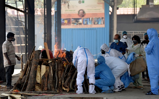 Nhân viên y tế và người nhà cầu nguyện lần cuối cho bệnh nhân COVID-19 xấu số trước lễ hỏa táng ở thủ đô New Delhi. (Ảnh: ANI)