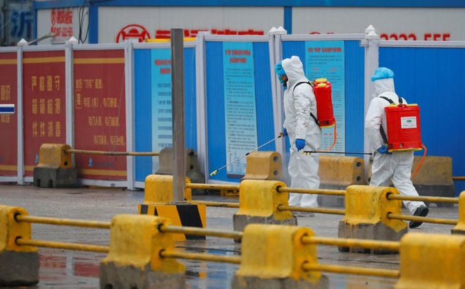 Các nhân viên phun khử khuẩn tại một khu chợ ở Vũ Hán, tỉnh Hồ Bắc tháng 3/2021. Ảnh: Reuters