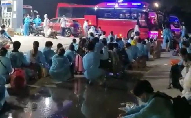 Công nhân ở trọ tại ổ dịch thôn Núi Hiểu, xã Quang Châu, huyện Việt Yên, ngồi đợi gọi tên lên xe ô tô để di chuyển khỏi ổ dịch này đến khu cách ly tập trung của huyện Việt Yên.