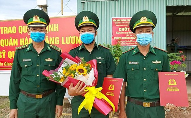 Đại tá Huỳnh Văn Đông (bên trái) - Chính ủy Bộ đội Biên phòng tỉnh Kiên Giang trao quyết định thăng quân hàm cho các sĩ quan tại chốt phòng, chống dịch.