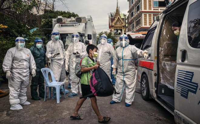 Một bé trai ở Khlong Toey xách balo lên xe cấp cứu. Ảnh: Bangkok Post