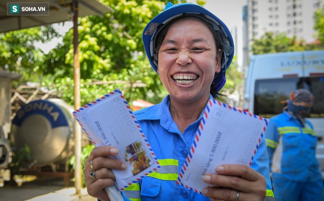 Chị Nguyễn Thị Bưởi cười tươi bên 2 phong bì chứa tiền ủng hộ của các nhà hảo tâm. Ảnh: Việt Hùng.