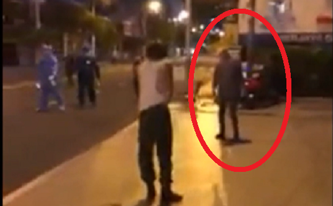 Lực lượng chức năng đuổi theo người đàn ông (khoanh đỏ). Ảnh cắt từ video đăng trên báo Giao thông.