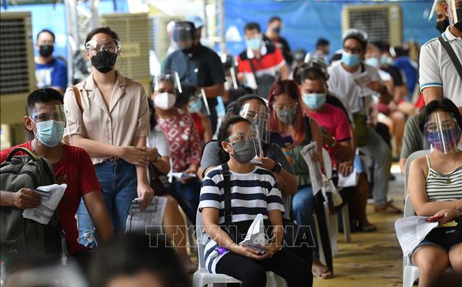 Người dân đợi tiêm vaccine ngừa COVID-19 tại Mandaluyong, ngoại ô Manila, Philippines. Ảnh: AFP/TTXVN