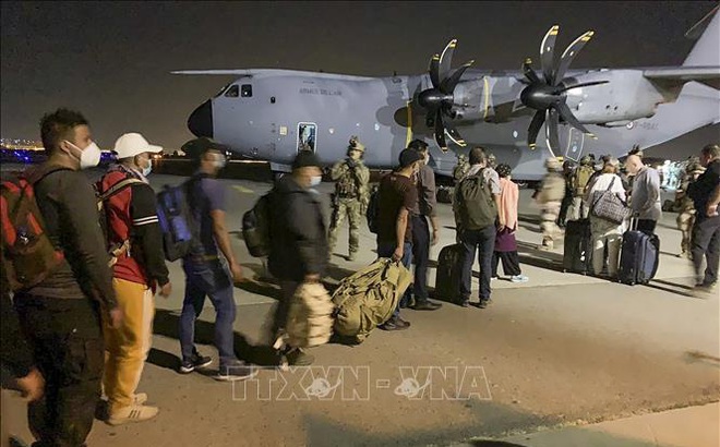 Công dân Pháp cùng đồng sự Afghanistan xếp hàng chờ lên máy bay rời Afghanistan tại sân bay Kabul ngày 17/8/2021. Ảnh: AFP/TTXVN