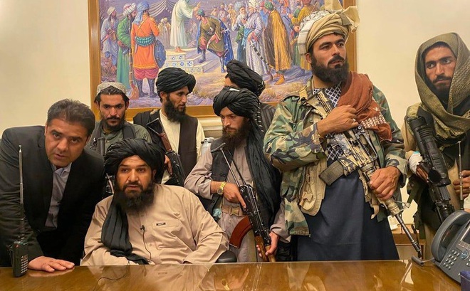 Các chiến binh Taliban ngồi vào bàn làm việc của Tổng thống Afghanistan Ashraf Ghani, người đã bỏ trốn khỏi đất nước hôm 15/8 chỉ vài giờ trước đó.