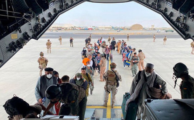 Người dân Afghanistan và công dân Tây Ban Nha lên máy bay quân sự tại sân bay quốc tế Hamid Karzai ở thủ đô Kabul - Afghanistan hôm 18-8 Ảnh: REUTERS
