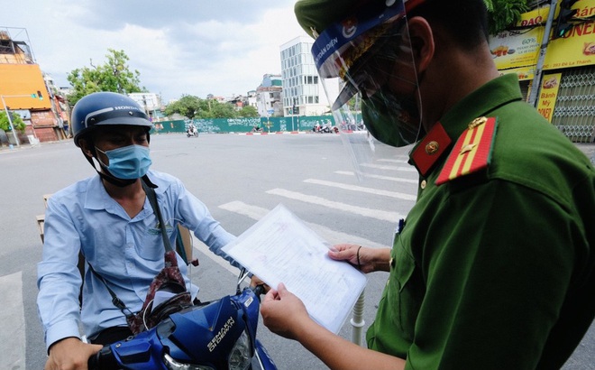 Lực lượng chức năng kiểm tra giấy đi đường của người dân.