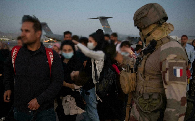 Người dân ở Afghanistan xếp hàng chờ lên máy bay tại sân bay ở Kabul ngày 26/8. Ảnh: AFP.