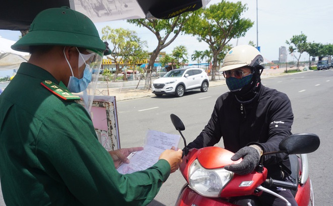 Lực lượng chức năng kiểm gia giấy đi đường của người dân lưu thông qua chốt kiểm soát dịch trên đường 2-9, quận Hải Châu, TP Đà Nẵng vào trưa 6-8