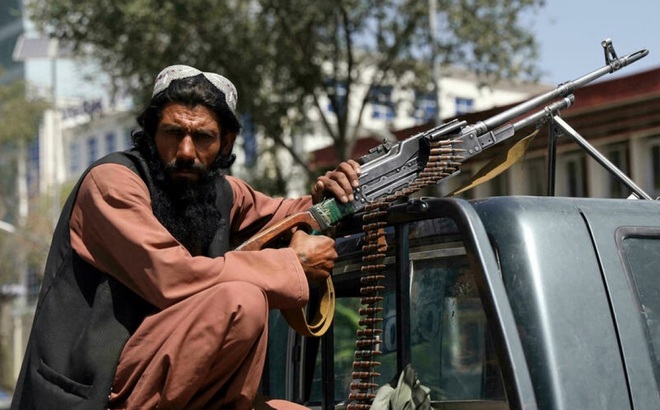 Chiến binh Hồi giáo Taliban cùng súng máy gắn trên xe bán tải cạnh phủ tổng thống Afghanistan vào tháng 8/2021. Ảnh: AP.