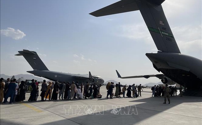 Các công dân xếp hàng chờ lên máy bay quân sự Mỹ ở sân bay quốc tế Kabul để sơ tán khỏi Afghanistan, ngày 22/8/2021. Ảnh: THX/TTXVN