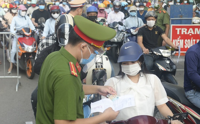 Lực lượng công an kiểm tra giấy đi đường của người dân.