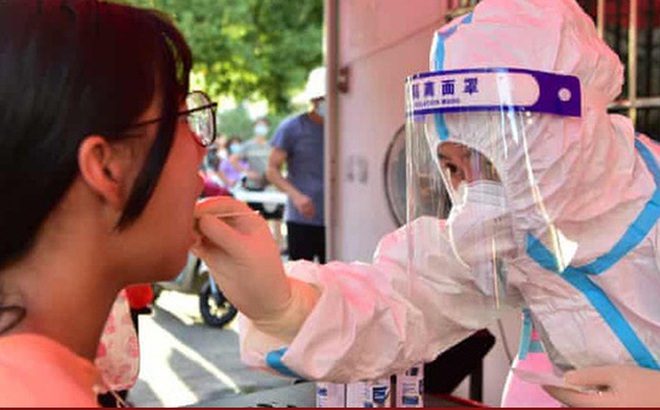 Nhân viên y tế lấy mẫu xét nghiệm COVID-19 tại tỉnh Phúc Kiến - Trung Quốc. Ảnh: The Guardian