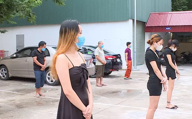 Nhóm cô gái mặc váy 2 dây và váy ngắn cùng các nam thanh niên bị phát hiện tại quán karaoke Anh Vy - Ảnh: Công an cung cấp