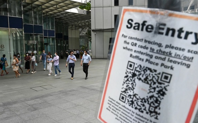 Người dân Singapore tuân thủ quy định đeo khẩu trang và cài ứng dụng giúp truy vết nhanh chóng. Ảnh: AFP