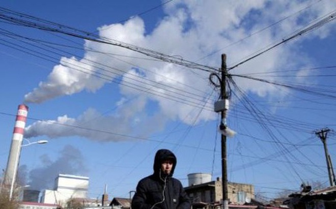 Một người đàn ông đang đi gần nhà máy điện than ở Cáp Nhĩ Tân, tỉnh Hắc Long Giang, Trung Quốc. (Ảnh: Reuters).