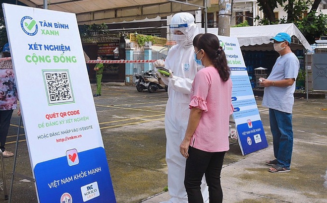 Nhân viên y tế hướng dẫn người dân Tân Bình quét mã QR để đăng ký xét nghiệm