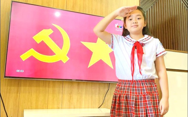 Học sinh ở Nghệ An đứng chào cờ qua tivi tại nhà và theo dõi lễ khai giảng trực tuyến.