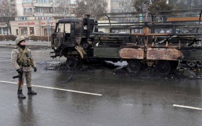 Binh sĩ Kazakhstan đứng gác gần một chiếc xe tải bị cháy trên đường phố thành phố Almaty, ngày 8/1. Ảnh: Reuters.
