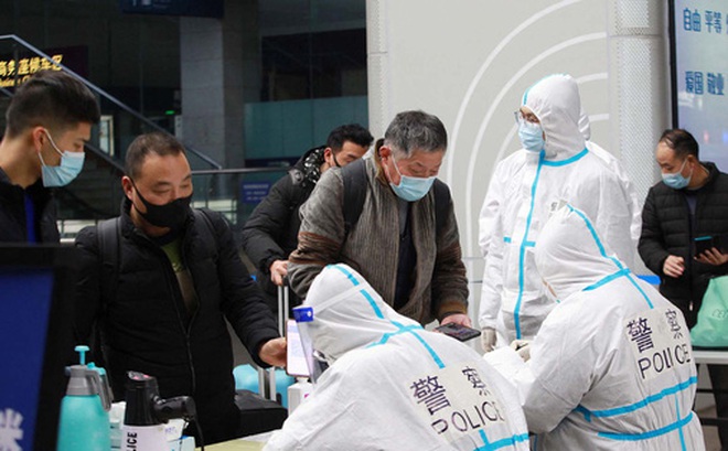 Cảnh sát mặc đồ bảo hộ kiểm tra thông tin sức khỏe của hành khách tại ga TP Nam Kinh, tỉnh Giang Tô - Trung Quốc hôm 17-1 Ảnh: REUTERS