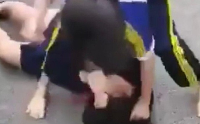 Nữ sinh bị đánh liên tiếp vào mặt, giật tóc và kéo lê dưới đất. (Ảnh cắt từ Clip)