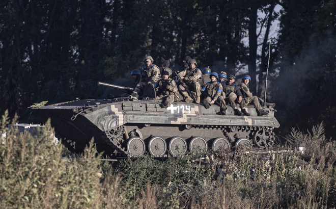Binh sĩ Ukraine ngồi trên thiết giáp gần một ngôi làng ở tỉnh Kharkov. Ảnh: AFP