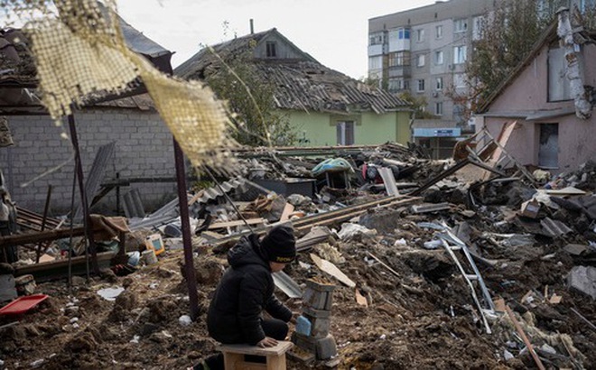 Một cậu bé chơi giữa đống đổ nát của ngôi nhà của bà mình ở thành phố Kupiansk, tỉnh Kharkov, đông bắc Ukraine hôm 16-10 - Ảnh: REUTERS