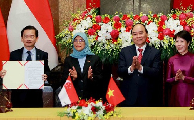 Tổng thống Singapore Halimah Yacob, Chủ tịch nước Việt Nam Nguyễn Xuân Phúc, đại diện Bộ Kế hoạch và Đầu tư (thứ hai, ba, tư từ trái sang) trao quyết định chấp thuận chủ trương cho đại diện chủ đầu tư khu công nghiệp Việt Nam - Singapore - Ảnh: NGUYỄN KHÁNH