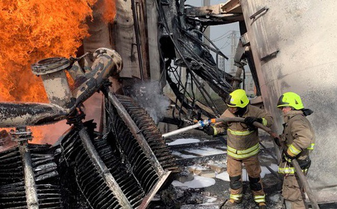 Nhân viên cứu hỏa dập lửa tại một cơ sở hạ tầng về năng lượng - Ảnh: REUTERS