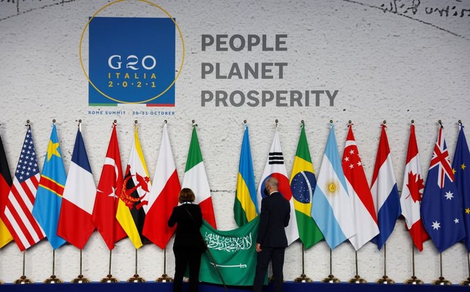 Nhân viên treo quốc kỳ Saudi Arabia trong quá trình chuẩn bị trước cuộc hội nghị thượng đỉnh các nhà lãnh đạo G20 tại trung tâm hội nghị La Nuvola, ở Rome, ngày 30/10/2021. Ảnh: Reuters