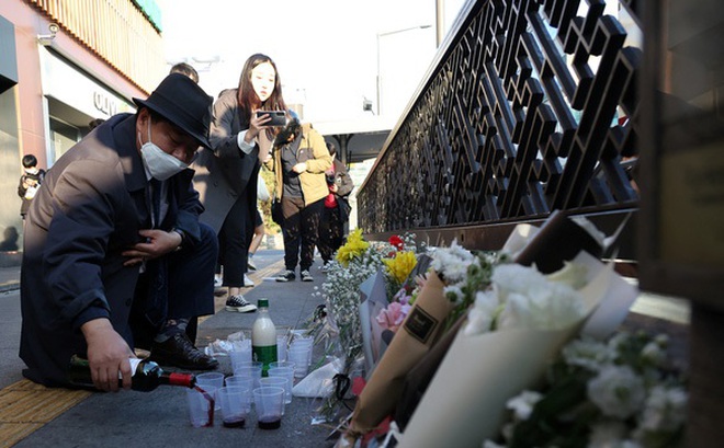 Người dân Hàn Quốc rót rượu, đặt hoa tại nơi gần hiện trường vụ giẫm đạp tối 29-10 - Ảnh: REUTERS
