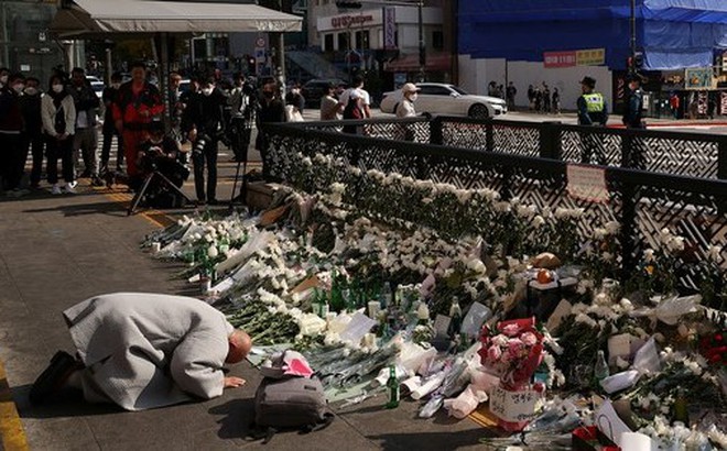 Người dân đặt hoa, nến, những món ăn yêu thích của người quá cố, khóc và cầu nguyện tại địa điểm xảy ra thảm kịch giẫm đạp ở Itaewon, TP Seoul - Hàn Quốc Ảnh: REUTERS