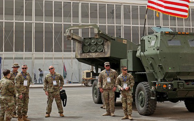 Quân nhân Mỹ đứng bên hệ thống tên lửa cơ động cao M142 (HIMARS) - Ảnh: AFP