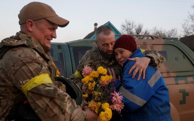 Bà Valentyna Buhaiova, người dân ở Kherson, ôm hai người lính thủy đánh bộ Ukraine ở làng Kyselivka, ngoại ô Kherson, Ukraine, ngày 12-11 - Ảnh: REUTERS