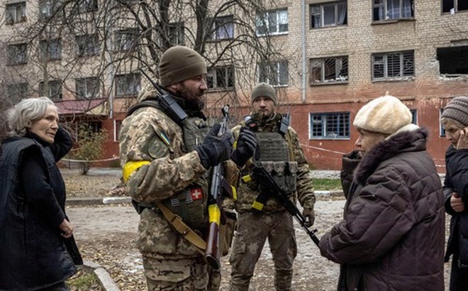 Quân nhân Ukraine nói chuyện với người dân địa phương sau khi Nga rút quân khỏi Kherson, Ukraine ngày 1-12-2022 - Ảnh: REUTERS