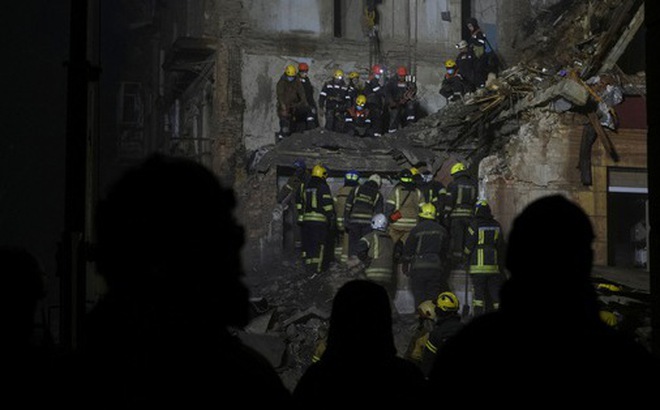 Lực lượng cứu hộ làm việc tại khu vực một tòa nhà dân bị hư hại do tên lửa Nga trong cuộc tấn công ở TP Kryvyi Rih, miền trung Ukraine hôm 16-12 - Ảnh: REUTERS