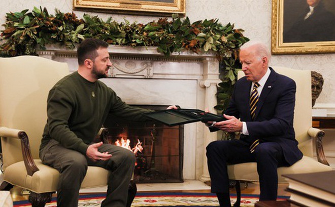 Tổng thống Ukraine Volodymyr Zelensky chuyển quà của một người lính Ukraine cho Tổng thống Mỹ Joe Biden tại Nhà Trắng ở Washington, Mỹ, ngày 21-12 - Ảnh: REUTERS