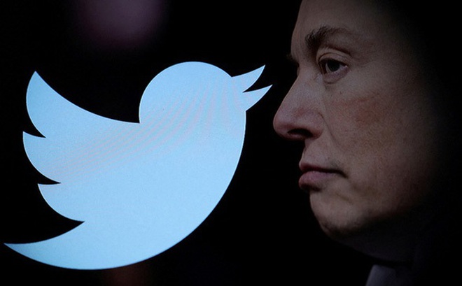 Tỉ phú Elon Musk bên logo của Twitter - Ảnh: REUTERS