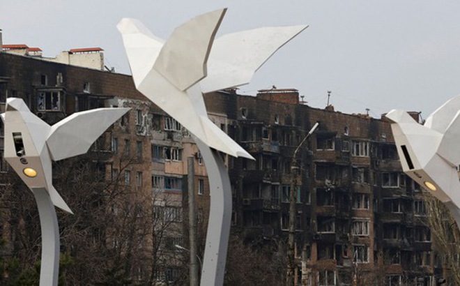 Các cột đèn hình chim bồ câu phía trước một tòa chung cư bị hư hại nặng nề trong cuộc xung đột Nga - Ukraine ở thành phố Mariupol vào ngày 24-12 - Ảnh: REUTERS