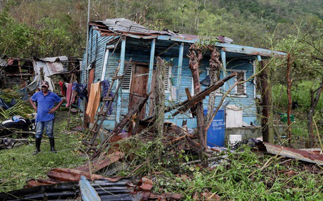 Người đàn ông đứng bên ngoài ngôi nhà bị phá hủy sau bão ở Cộng hòa Dominica. Ảnh: Reuters